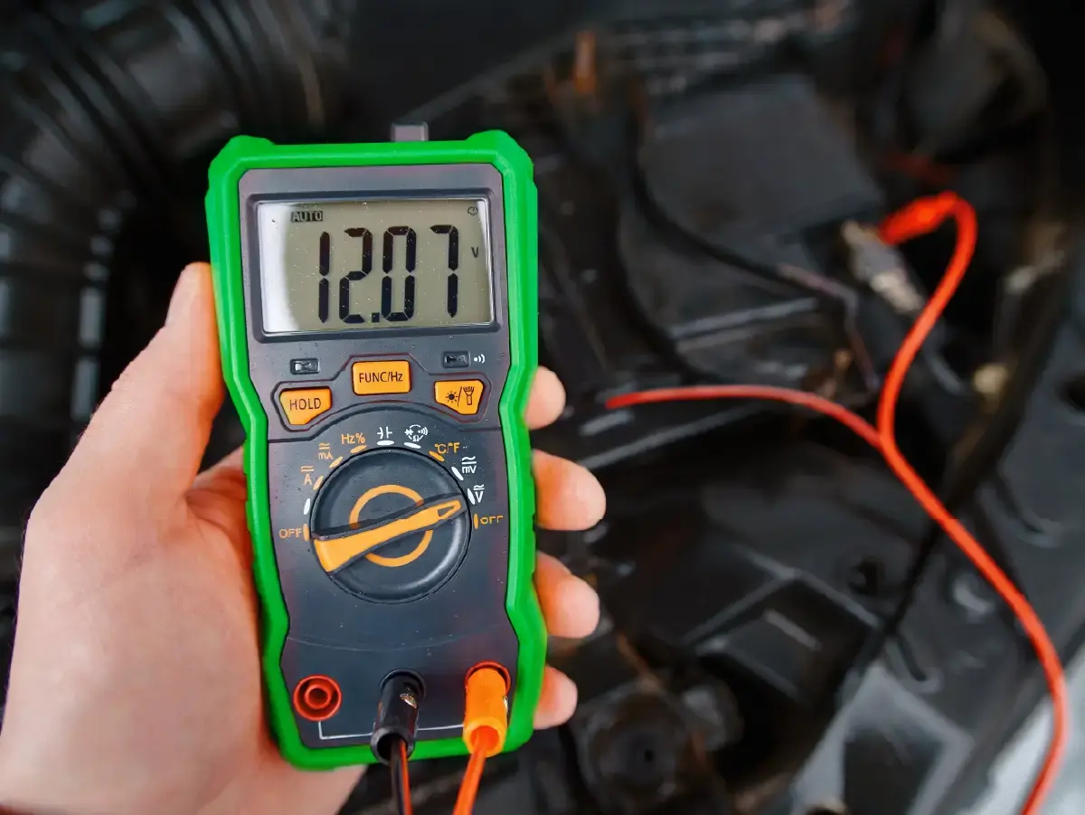 A car mechanic checking battery with a battery multimeter.webp